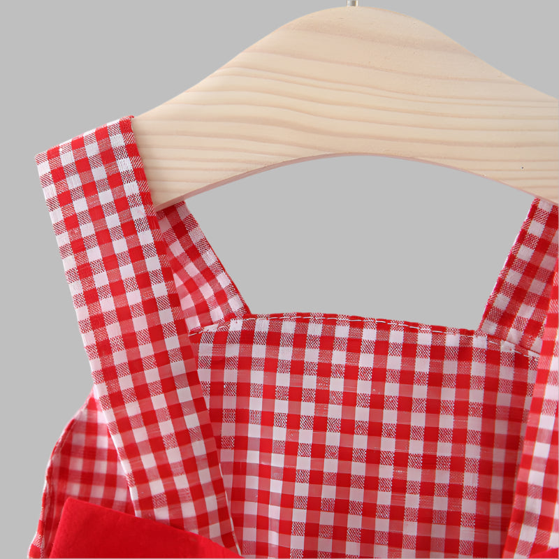 Red and white Gingham dress on a wooden hanger against a white background